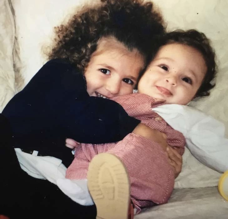 A childhood photo of two little ones cuddling